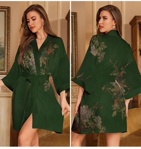 Detail of elegant dark green satin robe with vintage floral prints and matching waist tie