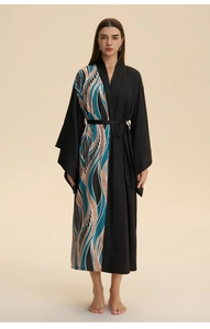 Detail view of luxury satin robe featuring an asymmetrical abstract wave print and waist tie