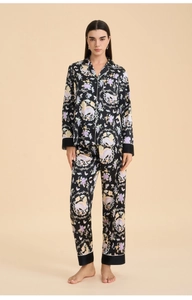 Detail of satin floral pajamas featuring colorful mythical creatures and contrast piping