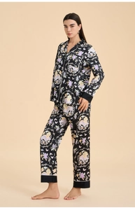 Detail of floral and butterfly print on black satin long-sleeve pajamas set
