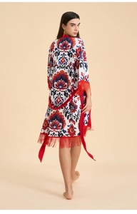 Vue détaillée du motif cachemire sur peignoir blanc avec franges rouges décoratives