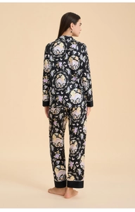 Rear view of black satin pajama set with floral and mythical creature print patterns