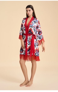 Détail du col en satin rouge et du peignoir floral soyeux avec bordure à franges