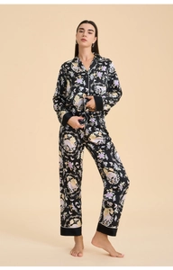 Detail of silk pajama cuffs and hem featuring floral patterns and white contrast piping