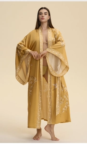 Detail of silk-like ginger yellow kimono robe with elegant crane and plum blossom patterns