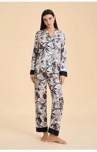 Detail of floral silk pajama sleeve with contrasting black trim and elegant pattern