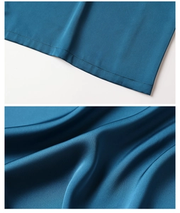 Close-up of peacock blue satin robe featuring neat hem stitching and silky fabric texture