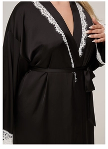 Detailed view of black satin robe with intricate white eyelash lace cuffs and neckline