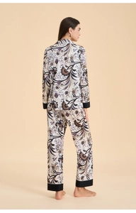 Detail view of the elegant floral print pajamas with contrasting black piped sleeve cuffs