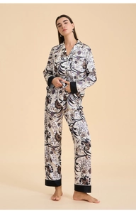Close-up of floral satin pajamas featuring black contrast piping and vintage prints