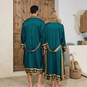 Detail of emerald green satin robe with gold baroque patterns on sleeves and hem