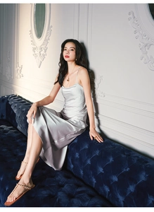 Detail of elegant champagne satin nightdress with slim straps and silky draped finish