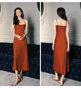Detail of burnt orange satin slip nightgown with thin straps and cowl neck draping