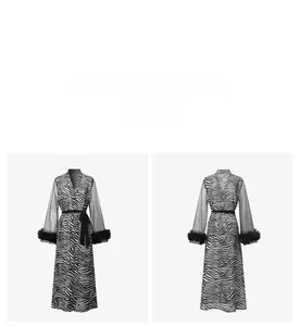 Detail of zebra print robe featuring mesh long sleeves and fluffy feather cuffs with tie belt