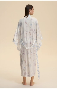 Rear view of a long satin floral kimono robe with lavender prints and matching waist belt