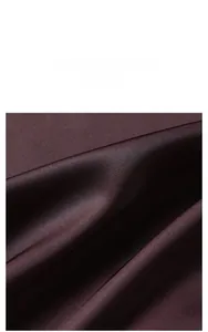 Détail d'un tissu satiné soyeux de luxe avec texture brillante pour peignoir femme