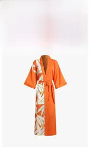 Detail of tropical leaf print and satin texture on long orange kimono bathrobe for women