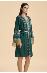 Détails de broderie florale et franges dorées sur le peignoir vert en satin de soie