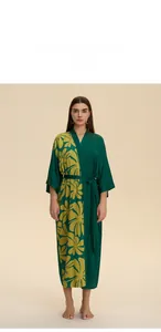 Detail of dark green satin robe with yellow tropical floral print and matching waist belt