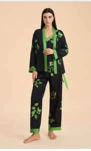 Detail of three-piece black satin pajama set with green leaf print and contrast piping