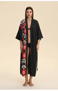 Detail view of a long black floral satin kimono robe with elegant red blossoms