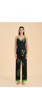 Detail of three-piece satin sleepwear set featuring V-neck camisole and green leaf patterns