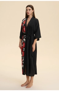 Detail of elegant black satin long kimono robe with red floral prints and sash belt