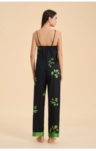 Back view of black satin pajama set with green leaf print and wide leg hem detail