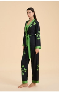 Detailed close-up of long sleeve satin pajama set with green leaf print and silk texture