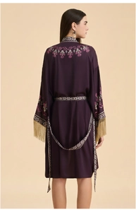 Détail de la robe en soie violette avec broderie florale et finitions à franges dorées