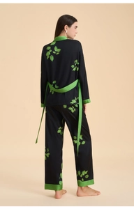 Rear view of women's floral satin pajamas showing the elegant green piping and tie waist