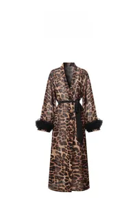 Dettaglio di una vestaglia leopardata con eleganti piume nere ai polsini e cintura nera