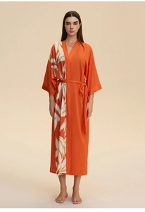 Detail of soft orange satin kimono robe with elegant leaf print and waist tie