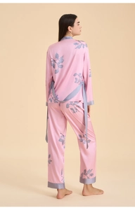 Rear view of three-piece satin sleepwear set showing fluid drape and purple leaf pattern