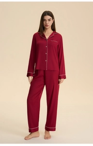 Detail of dark red satin pajamas set with white piping and silky texture finish
