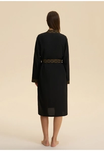 Back view of a long black kimono robe featuring elegant gold geometric trim details