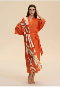 Detailed view of orange satin kimono robe with elegant white leaf print and silky texture
