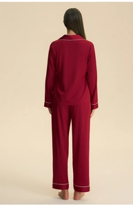 Detail view of the back of deep red satin pajamas with white contrast piping for couples