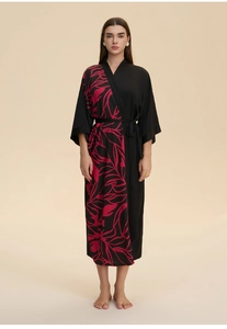Detail of soft black satin kimono robe featuring a pink leaf print and wrap waist design