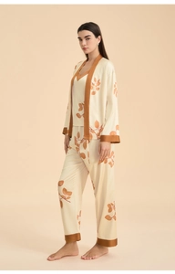 Macro detail of glossy satin fabric and leaf pattern on a 3-piece pajama set
