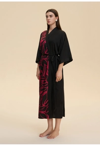 Detail of soft black satin kimono robe featuring a pink leaf print and wide sleeves