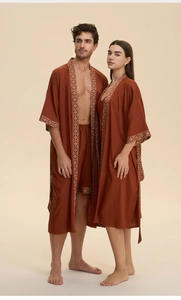 Detail of satin robes with retro geometric trim on cuffs and collar in brick red tone