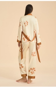 Back view of smooth satin long-sleeve pajama set with brown plant leaf patterns