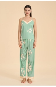 Detail of mint green satin pajama set with leaf print, featuring lace trim and silky texture