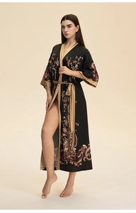 Détail des motifs paisley et du satin doré contrasté sur ce peignoir long noir élégant