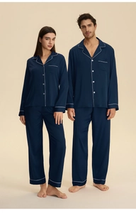 Detail of dark blue satin couple pajamas featuring classic white piping and lapel collar