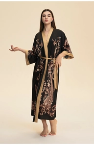 Détail d'un peignoir en satin noir avec motifs floraux cachemire dorés et ceinture fine