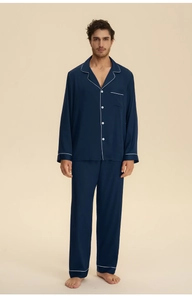 Detail view of navy satin pajama set with white piping and breast pocket detail