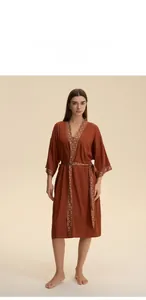Detail of rust red satin robe featuring ethnic geometric pattern on cuffs and neckline
