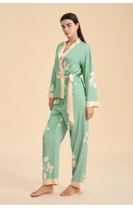 Detail of mint green satin pajama set featuring V-neck wrap top and leaf pattern print